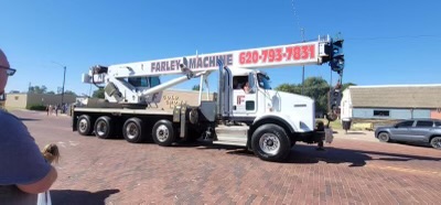 A crane loaded on a pull truck, both Farley Machine Works Co. branded vehicles